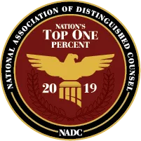Circular emblem stating "National Association of Distinguished Counsel, Nation's Top One Percent, 2019," featuring a gold eagle above a column and a laurel wreath on a red background.