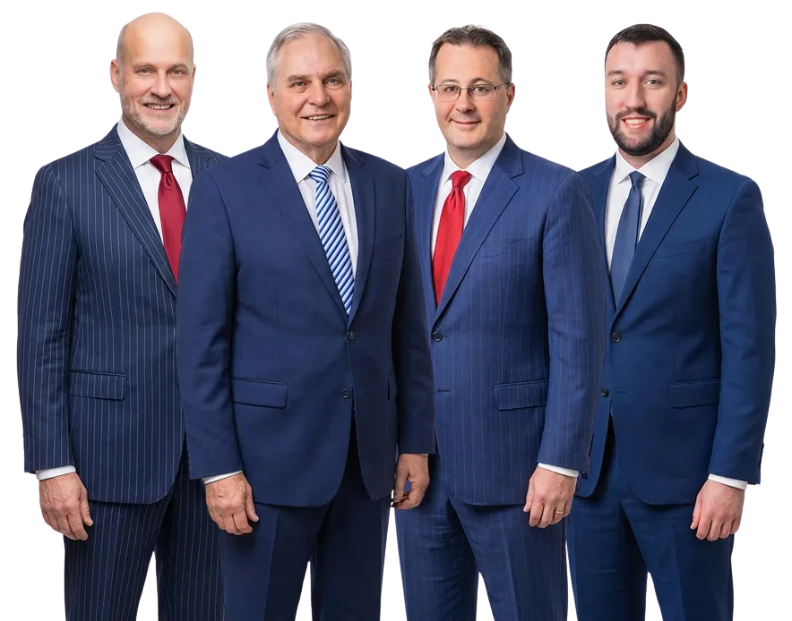 Four men wearing business suits stand side by side against a plain white background, facing the camera and smiling.